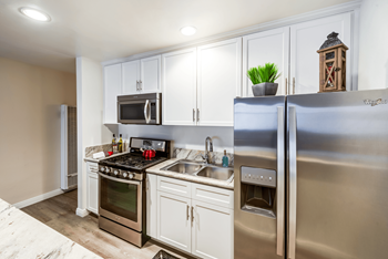 A kitchen with a stove, oven, refrigerator, and microwave.